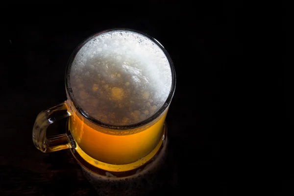 Beer in a glass with gold background — Stock Photo, Image