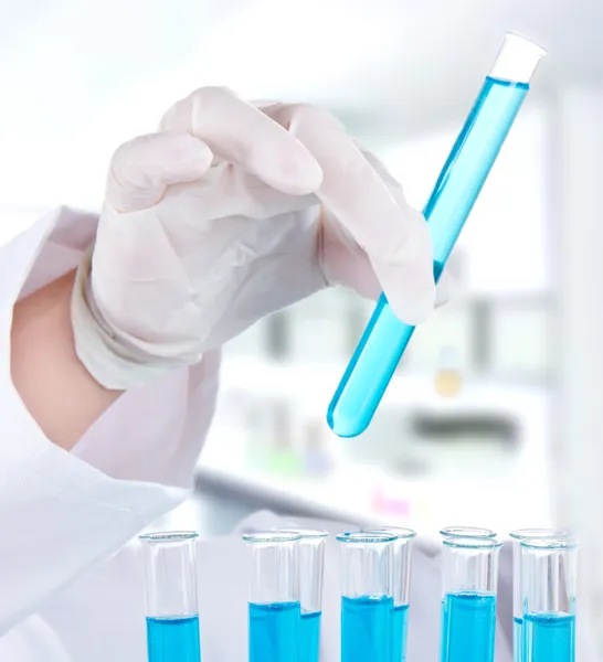 Investigadora com tubos de ensaio em laboratório — Fotografia de Stock