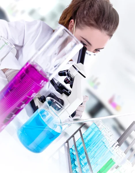 Investigador femenino con tubos de ensayo en laboratorio — Stockfoto