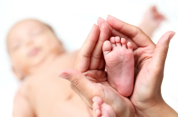 ママの手の中の赤ちゃんの足 — ストック写真