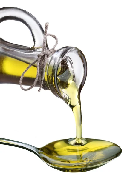 Оливковое масло наливают из бутылки в ложку . — стоковое фото