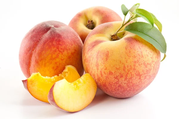 Reife Pfirsichfrüchte mit Blättern und Scheiben — Stockfoto
