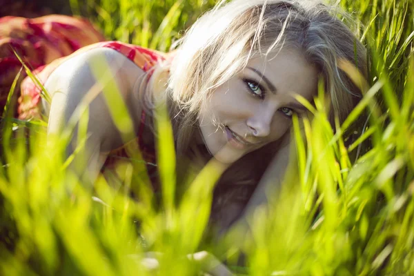 Menina bonita está em uma grama verde — Fotografia de Stock