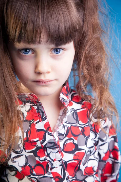 Schönes kleines Mädchen auf blauem Hintergrund — Stockfoto