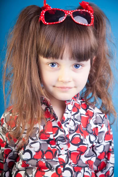 Красивая маленькая девочка на синем фоне — стоковое фото