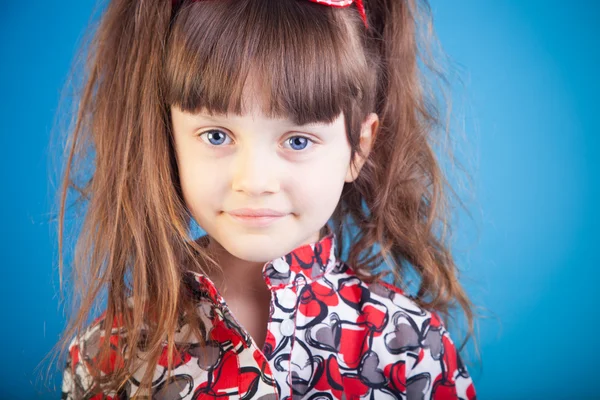 Beautiful little girl on a blue background — Stock Photo, Image
