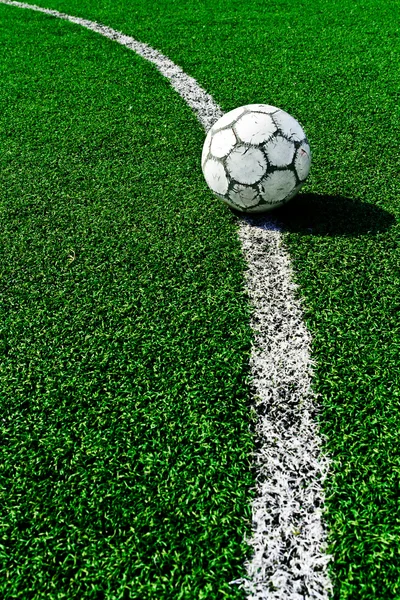 Old soccer ball on green grass — Stock Photo, Image