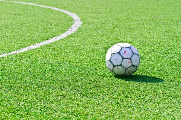 Старый футбольный мяч на зеленой траве — стоковое фото