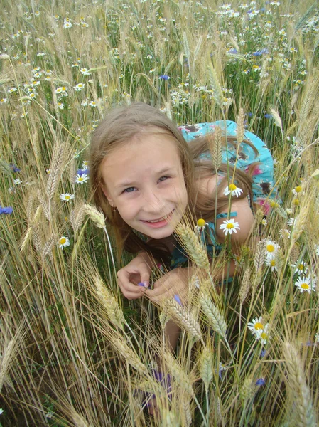 Ξανθιά κοπέλα παίζει Κρυφτό παιχνίδι στο πεδίο λουλούδια — Φωτογραφία Αρχείου