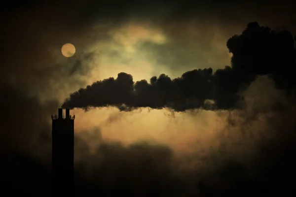 Soarele strălucește prin fum din coșurile de fum din fabrică, filmat prin telephoto . — Fotografie, imagine de stoc
