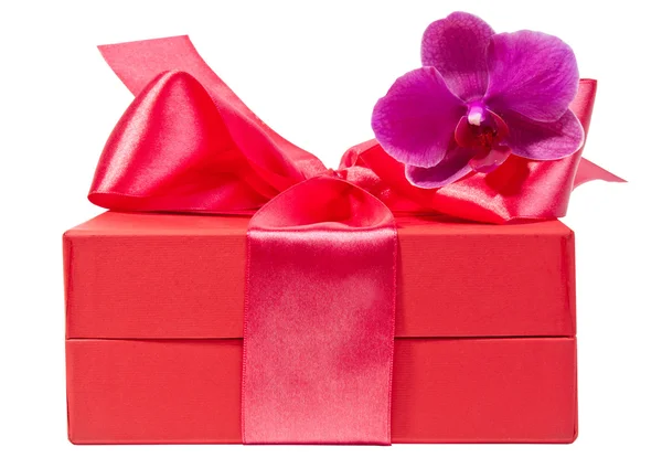Червона коробка зі стрічкою та квіткою — стокове фото