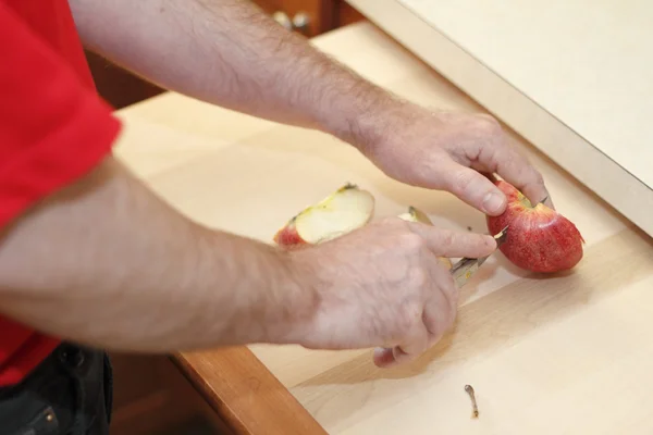 Мужские руки режут яблоко — стоковое фото