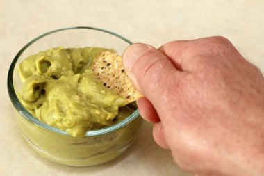 Hand Scooping Up Guacamole clipart