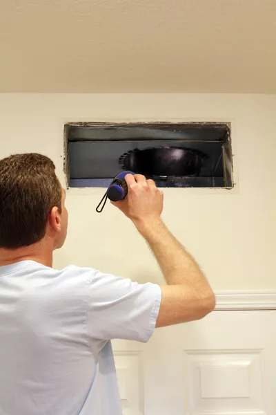Man Looking into Air Duct — Stock Photo, Image