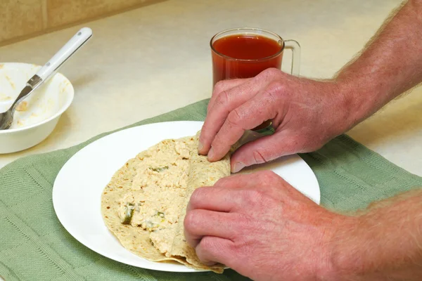 Händer rullande lax spridning i tortilla — Stockfoto