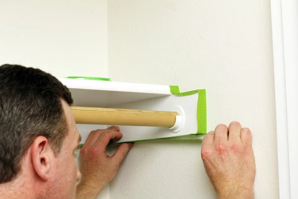 Man die van toepassing zijn groene schilder tape — Stockfoto