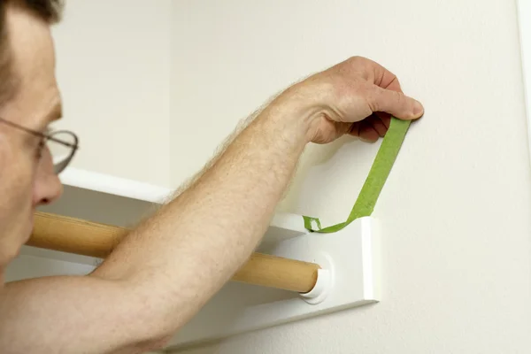Man peeling schilder tape — Stockfoto