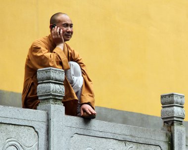 Buddhist monk with mobile phone clipart