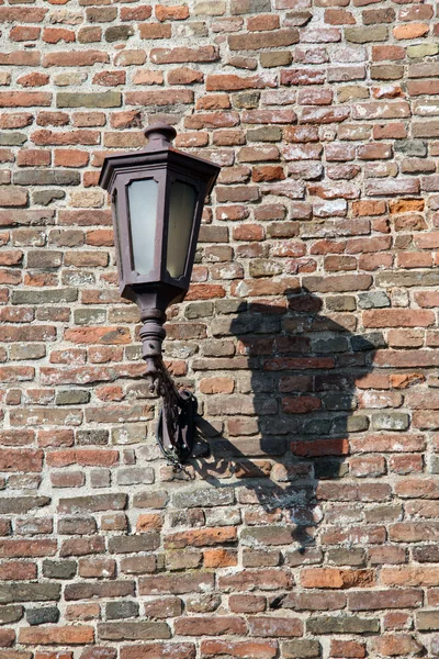 Lâmpada velha na parede de tijolo — Fotografia de Stock