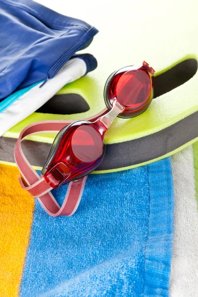 Colourful beach towel and swimming goggles — Stock Photo, Image