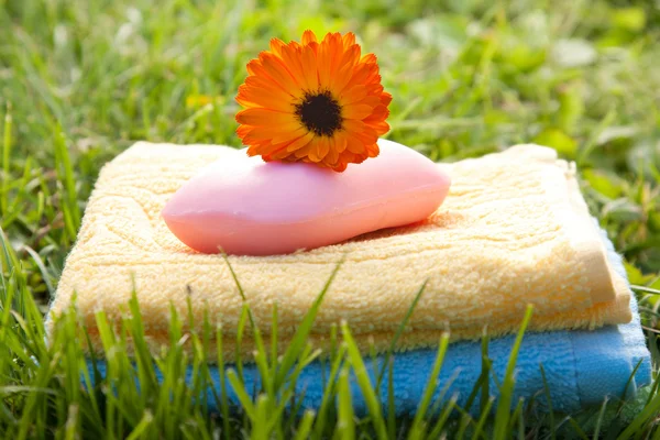 Ručníky a mýdlo v zelené trávě — Stock fotografie