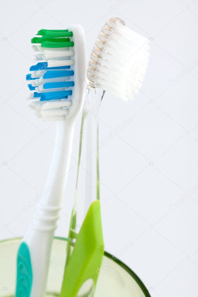 Two toothbrushes in a glass