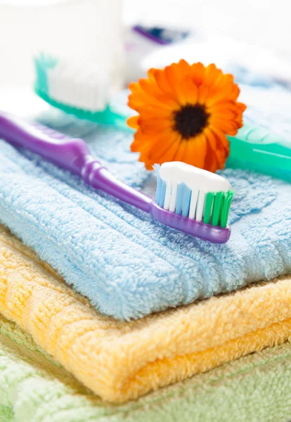 Toothbrush with toothpaste on fresh towels — Stock Photo, Image