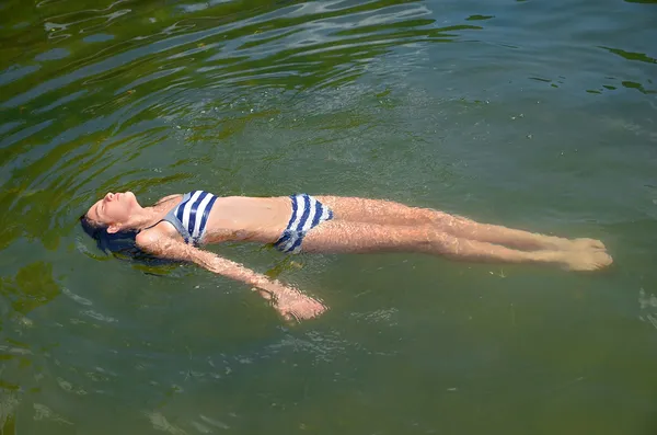 Chica preadolescente flotando en el agua —  Fotos de Stock