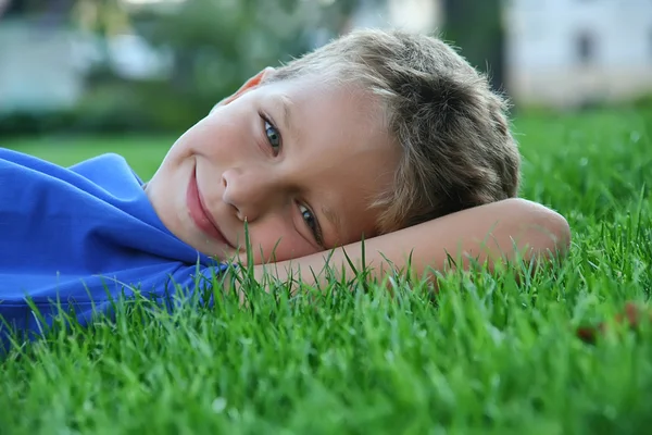 stock image Boy laying on a green grass