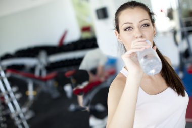 Girl drinking water in the gym