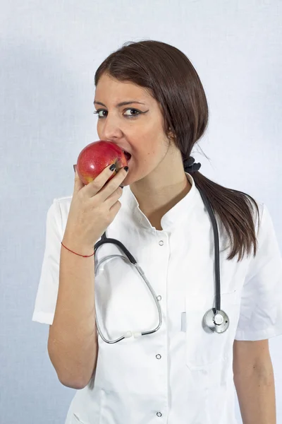 Arzt isst einen Apfel — Stockfoto