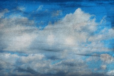 Clouds on a textured paper background clipart