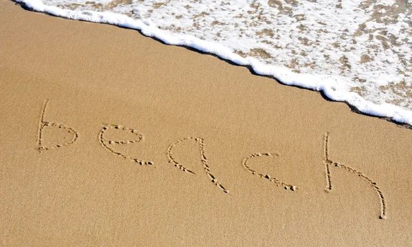 Palavra praia escrita na areia — Fotografia de Stock