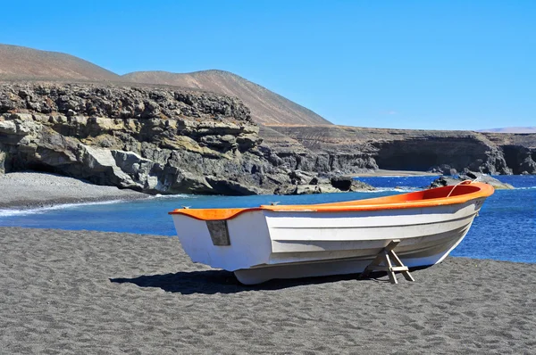 Barca in una spiaggia di sabbia nera a Fuerteventura, Spagna — Foto Stock