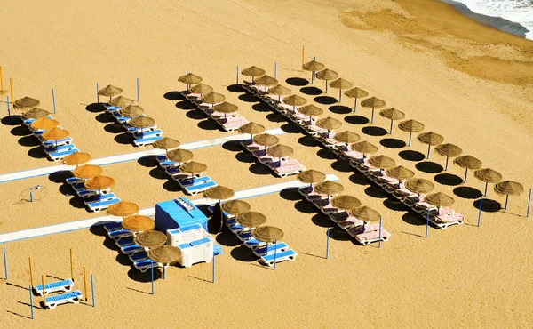 Пляж з сонячним годинником і парасольками — стокове фото