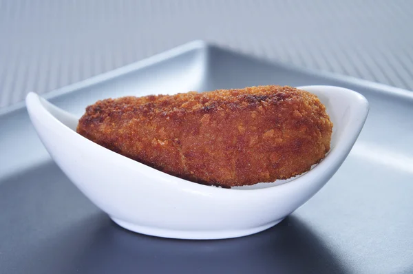 Croquete espanhol tradicional caseiro em um garfo no fundo