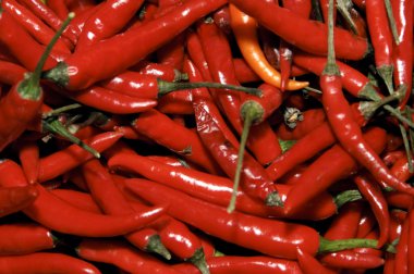 A pile of red hot chili peppers in a vegetables market clipart