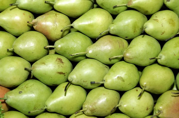 Una pila de peras en un mercado de verduras — Foto de Stock