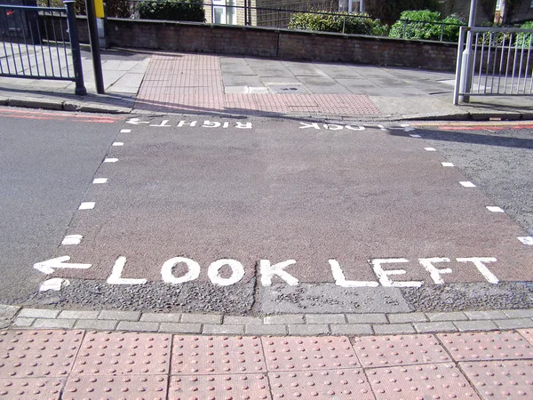 Mira a la derecha mira el letrero izquierdo en el cruce de cebra Londres — Foto de Stock