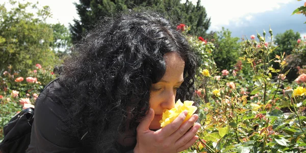 Όμορφη μελαχρινή μυρίζοντας τριαντάφυλλα — Stockfoto