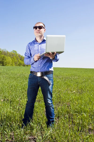 Businessmanon луг, с ноутбуком — стоковое фото