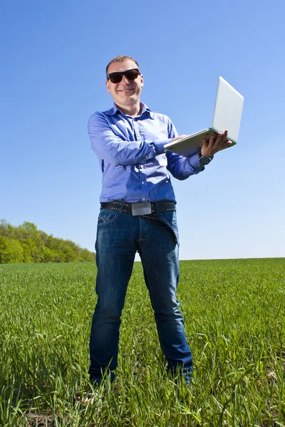 Businessmanon meadow, with a laptop — Stock Photo, Image