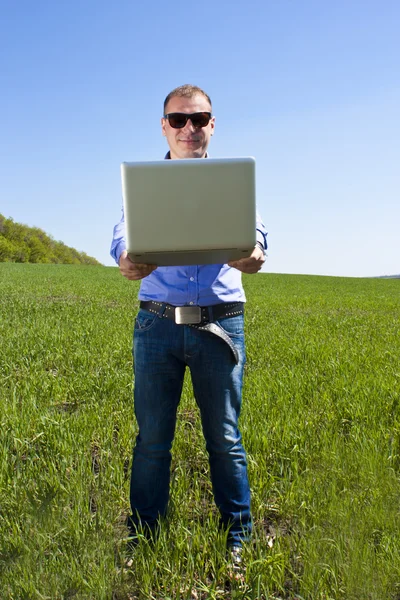 Businessmanon weide, met een laptop — Stockfoto