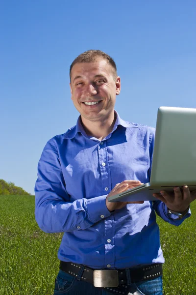 Businessmanon weide, met een laptop — Stockfoto