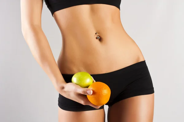Концепция здорового тела. Тонкий живот, фрукты — стоковое фото