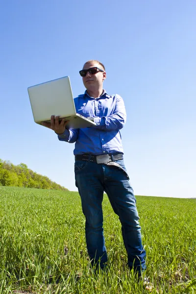 Businessmanon prairie, avec un ordinateur portable — Photo