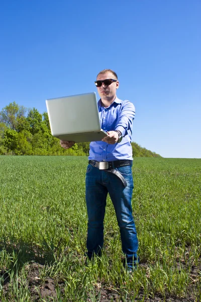 Businessmanon prairie, avec un ordinateur portable — Photo