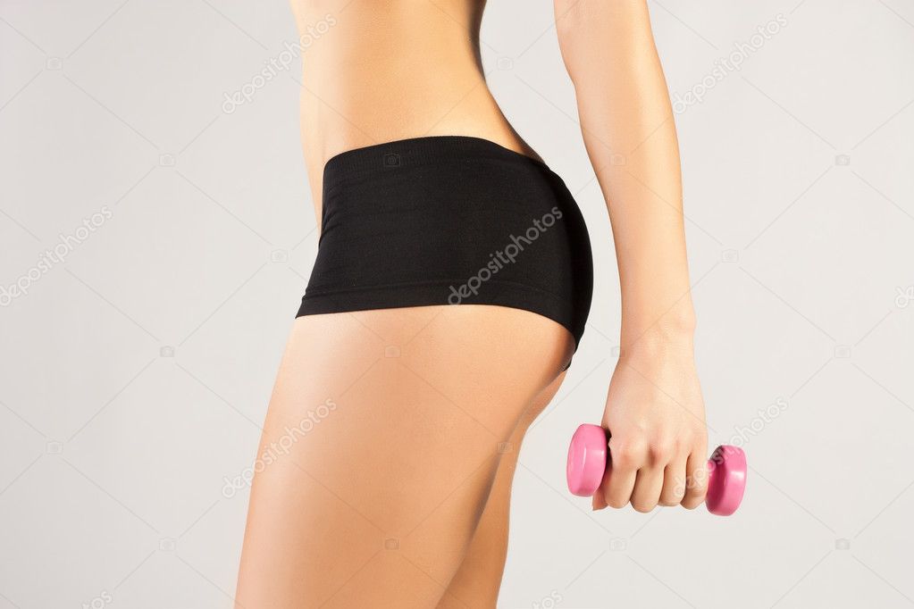 Nice sporty women body. Holding dumbbell