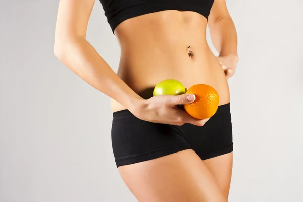 Концепция здорового тела. Тонкий живот, фрукты — стоковое фото