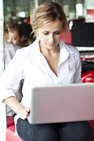 Щаслива молода красива жінка з ноутбуком - в приміщенні — стокове фото